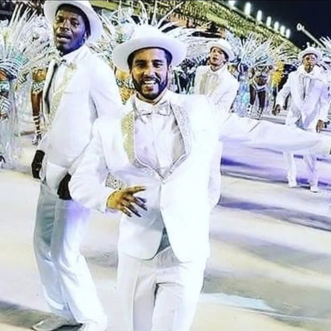 Camilo desfilando en traje blanco de passista en la Avenida del Sambódromo