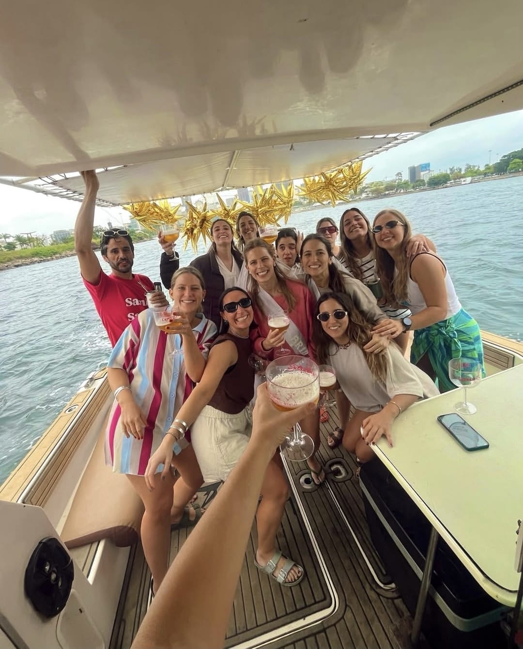 Brindis a bordo con globos dorados durante una fiesta en lancha en Río