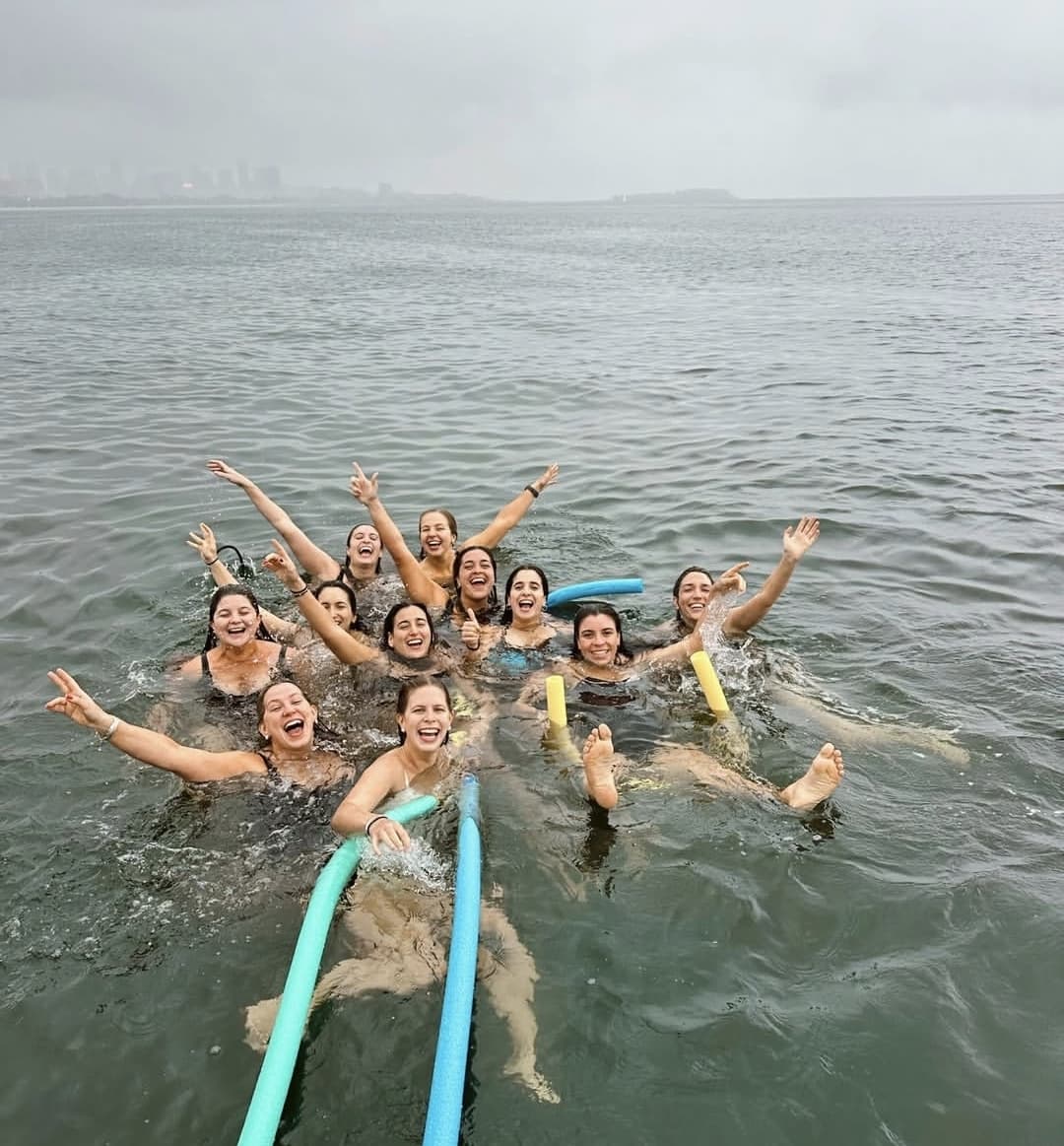 Grupo de amigas nadando desde la lancha en una parada del paseo por la bahía de Río de Janeiro