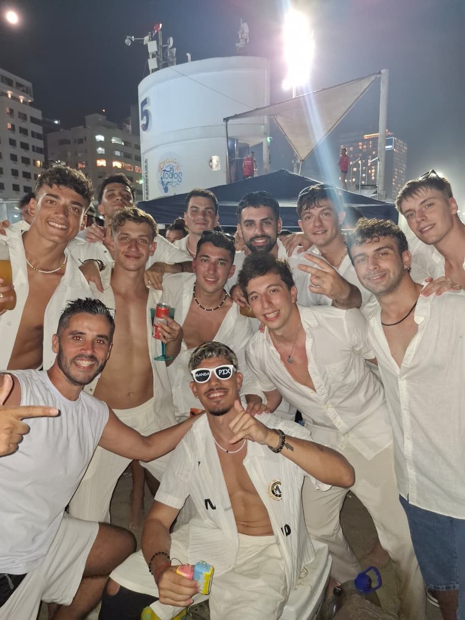 Grupo de viajeros vestidos de blanco en la playa de Copacabana para el Réveillon